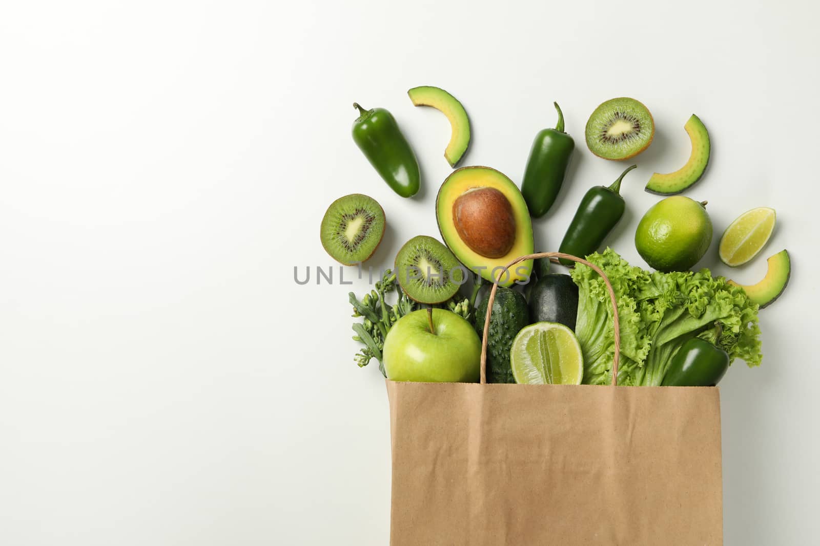 Paper bag with vegetables and fruits on white background