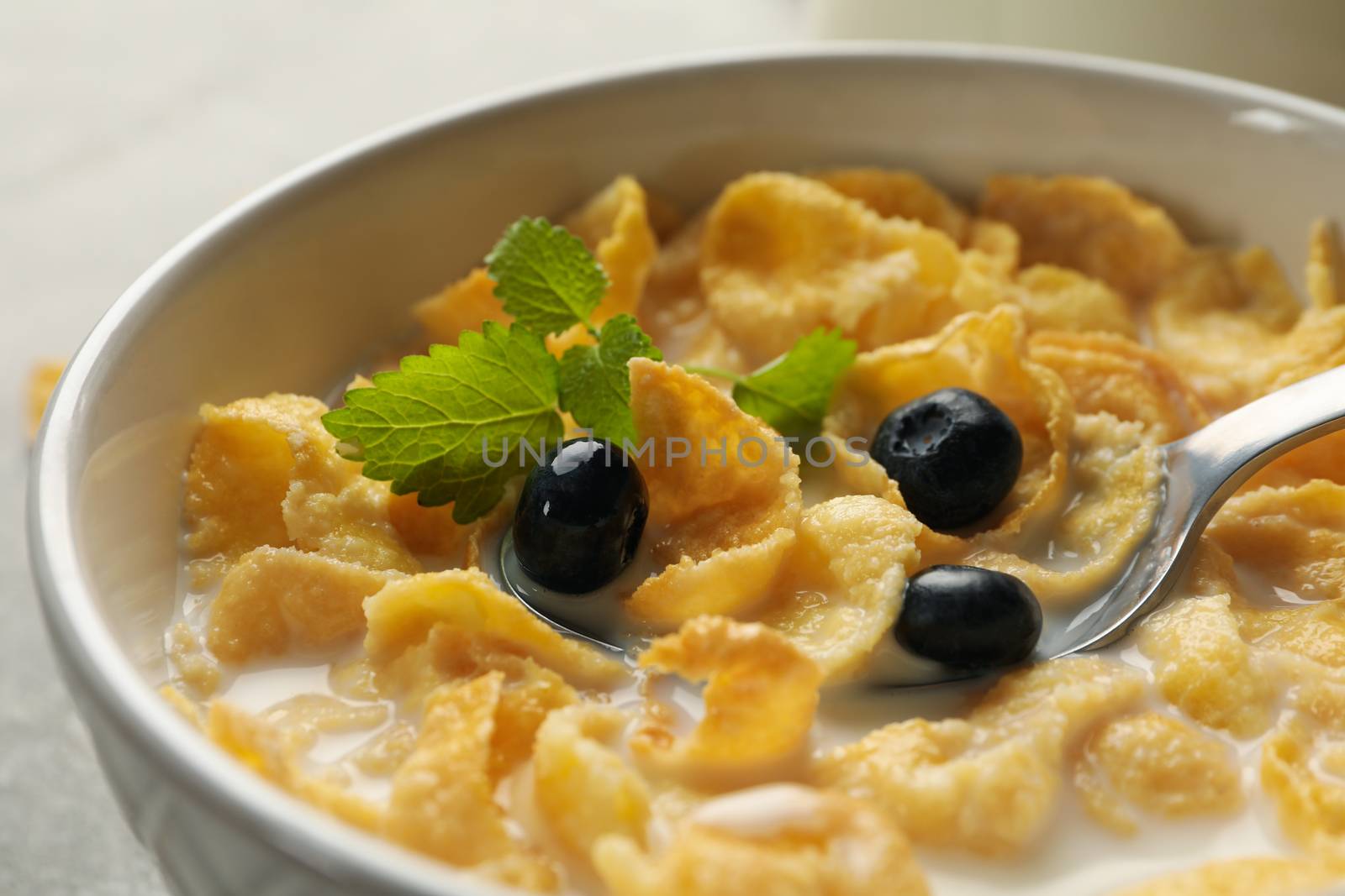 Muesli with milk, blueberry and spoon, close up by AtlasCompany