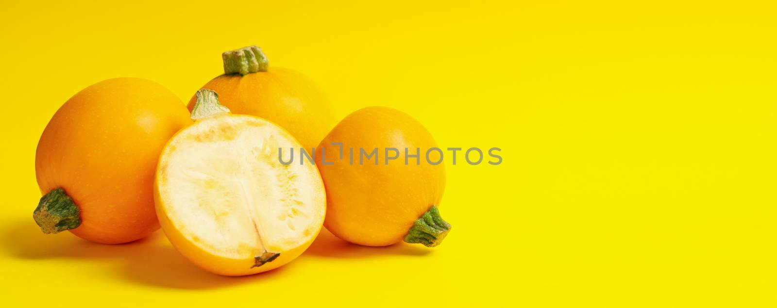 Round zucchini on yellow background, space for text