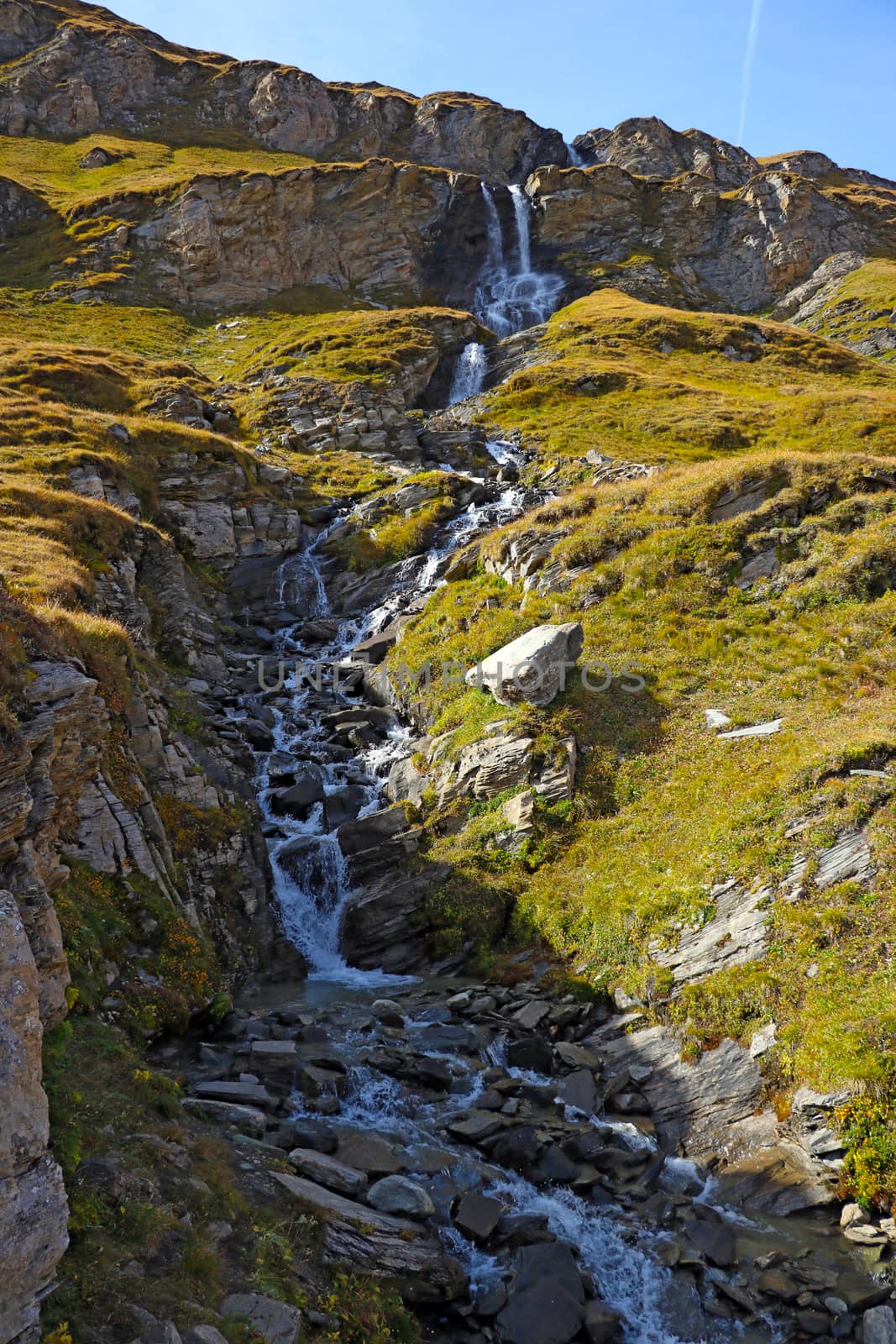 A small stream flows down the mountainside. by kip02kas