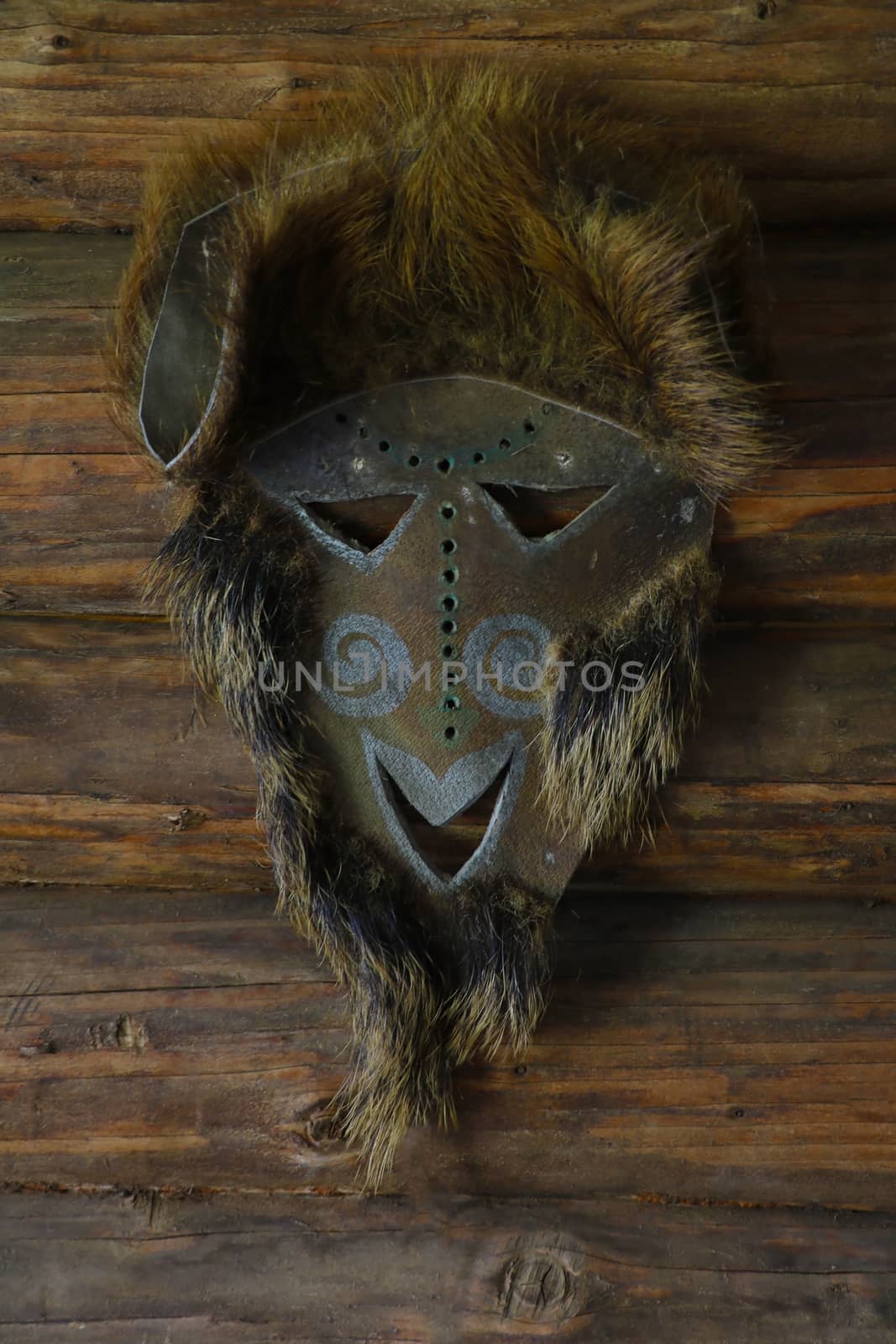 An animal skin mask hangs on the wall. by kip02kas