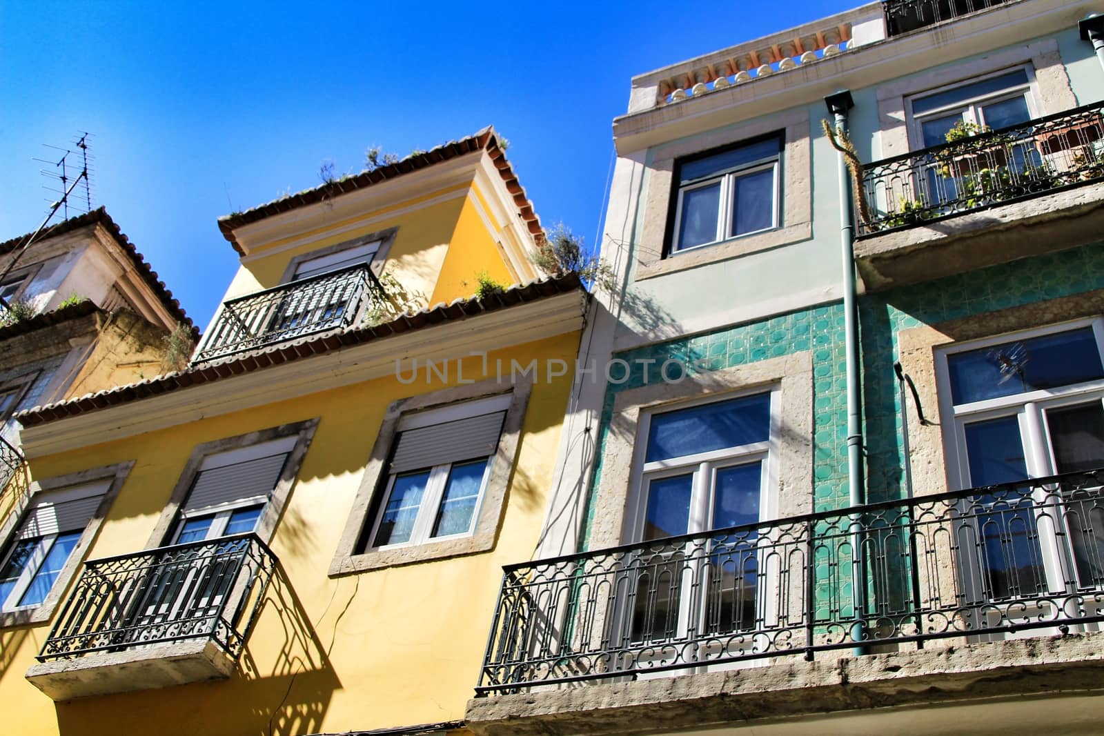 Old colorful and majestic tiled facades with vintage streetlight in Lisbon streets in Spring.