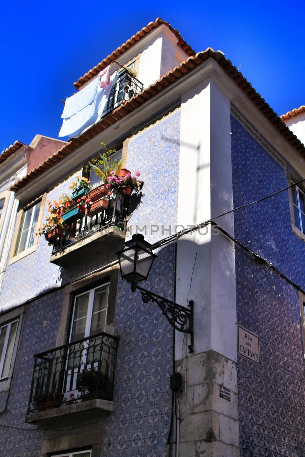 Old facade of typical Lisbon house with hanging clothes in clothesline.