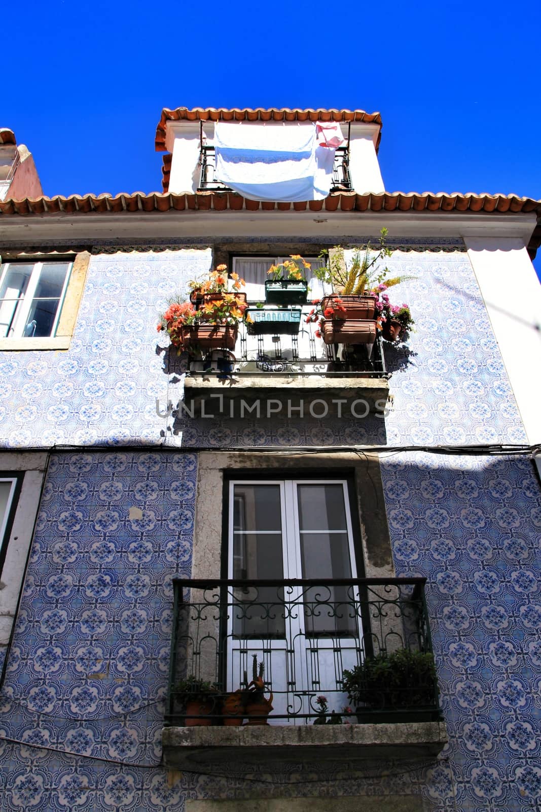 Old facade of typical Lisbon house with hanging clothes in clothesline.