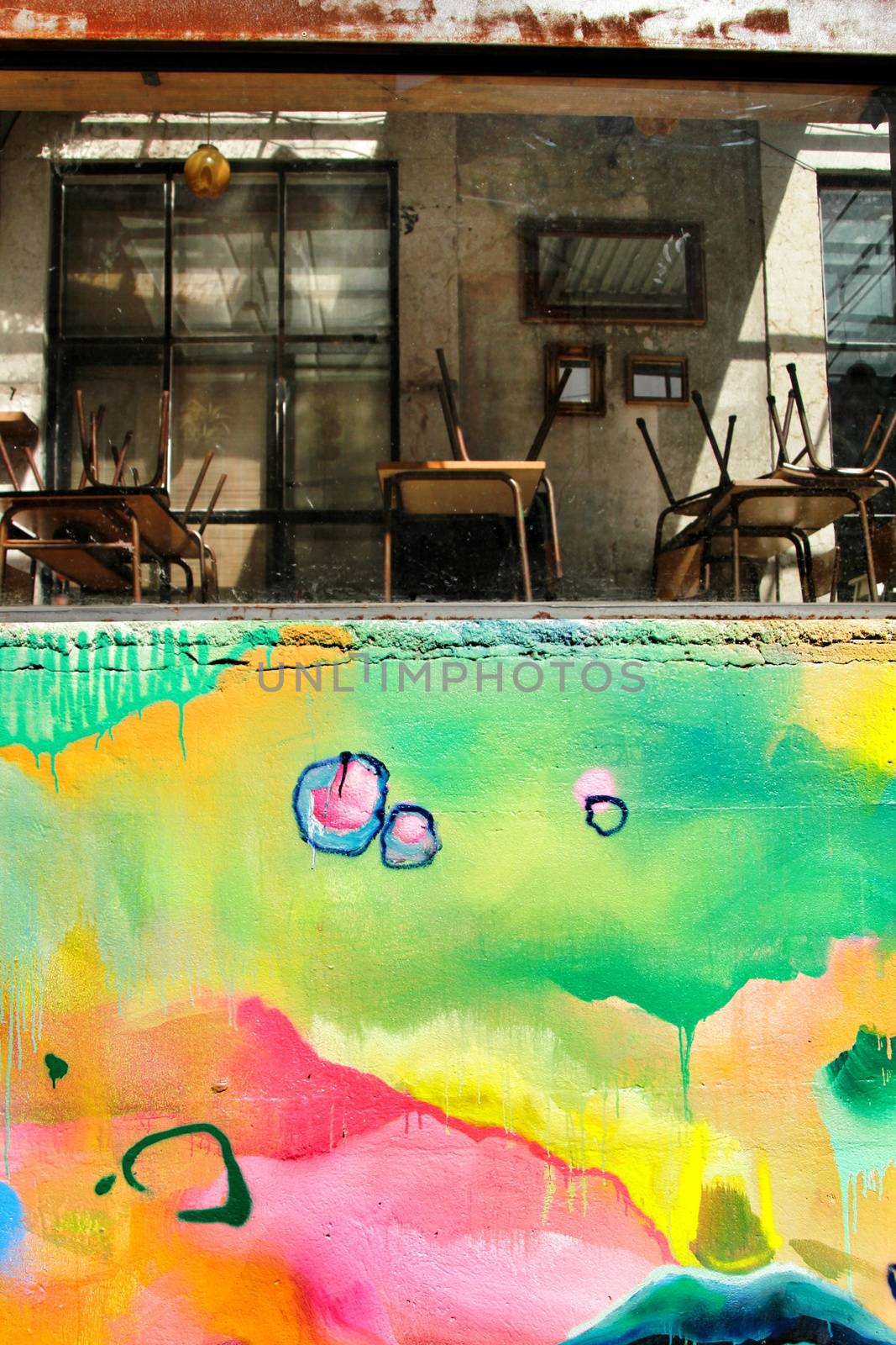 Closed restaurant with chairs and tables and colorful painted wall