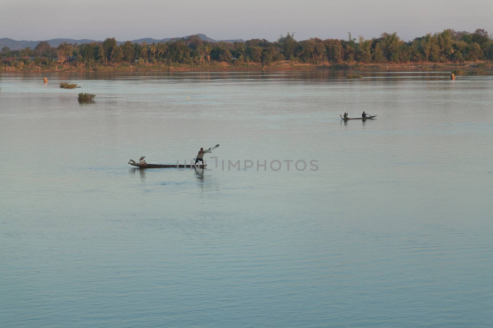 Muong Khong Laos 1.12.2012 Mekong river at sunset with and fishing boat and nets by kgboxford