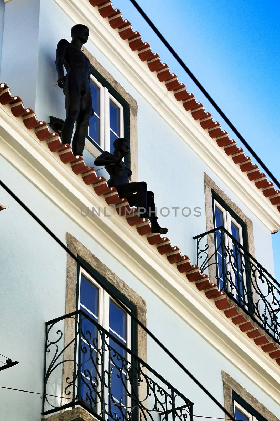 Colorful facade with two black mannequins in Lisbon in a sunny day of spring