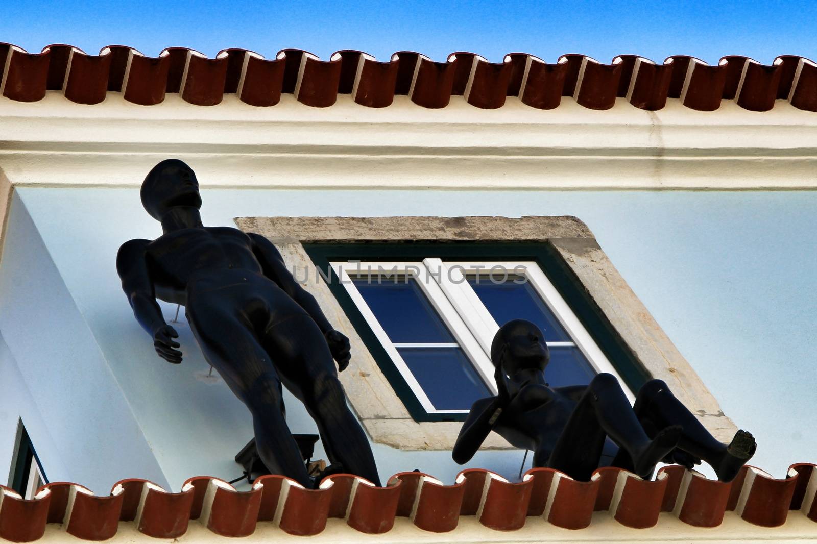 Colorful facade with two black mannequins in Lisbon in a sunny day of spring