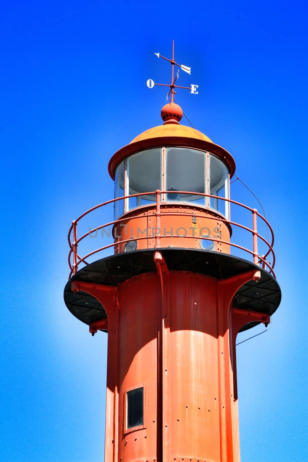 Red lighthouse in the port of Almada village in Lisbon on a sunny day of winter. 