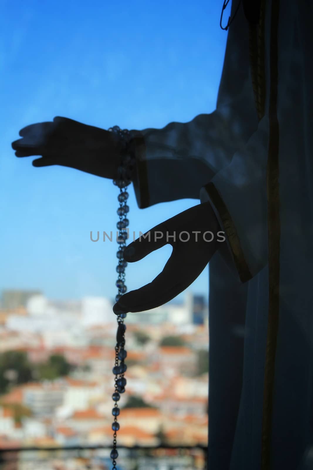 Image of the Virgin Mary hands holding a rosary in Nossa Senhora Do Monte viewpoint in Lisbon in a sunny day of winter