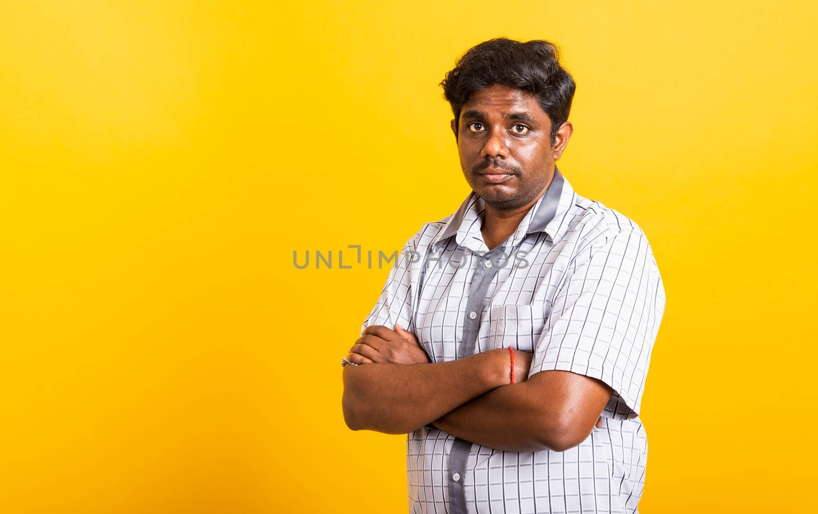 Closeup Asian happy portrait young black man standing cross arms chest confident pose and looking camera, studio shot isolated on yellow background