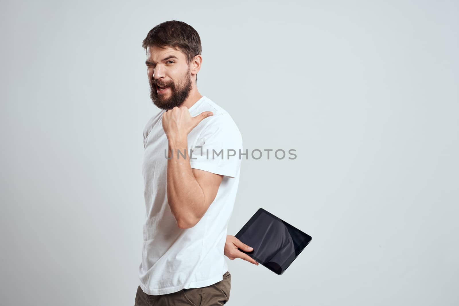 emotional man with tablet in hand touch screen new technologies light background cropped view Copy Space. High quality photo