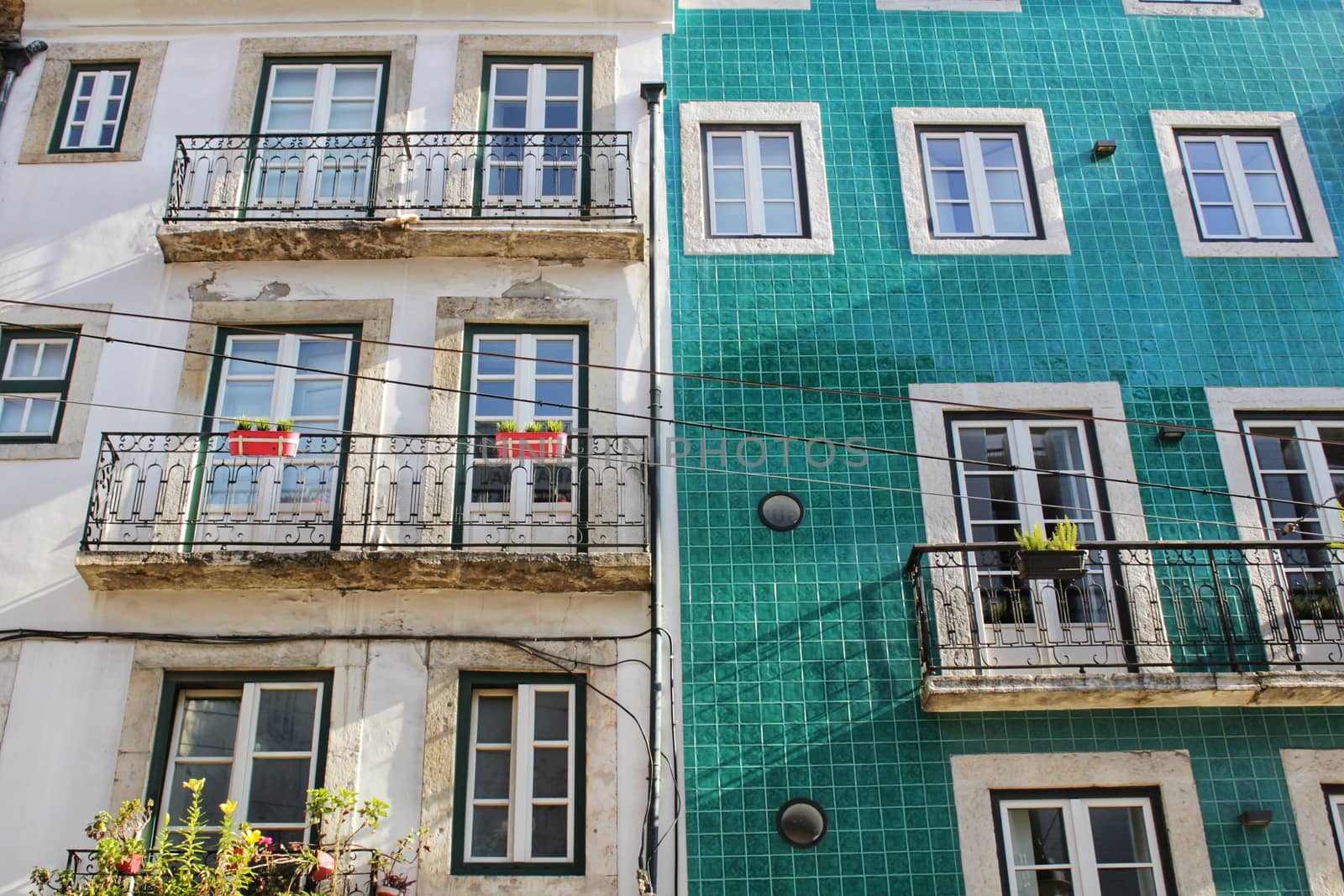 Old colorful and majestic tiled facades with vintage streetlight in Lisbon streets in Spring.