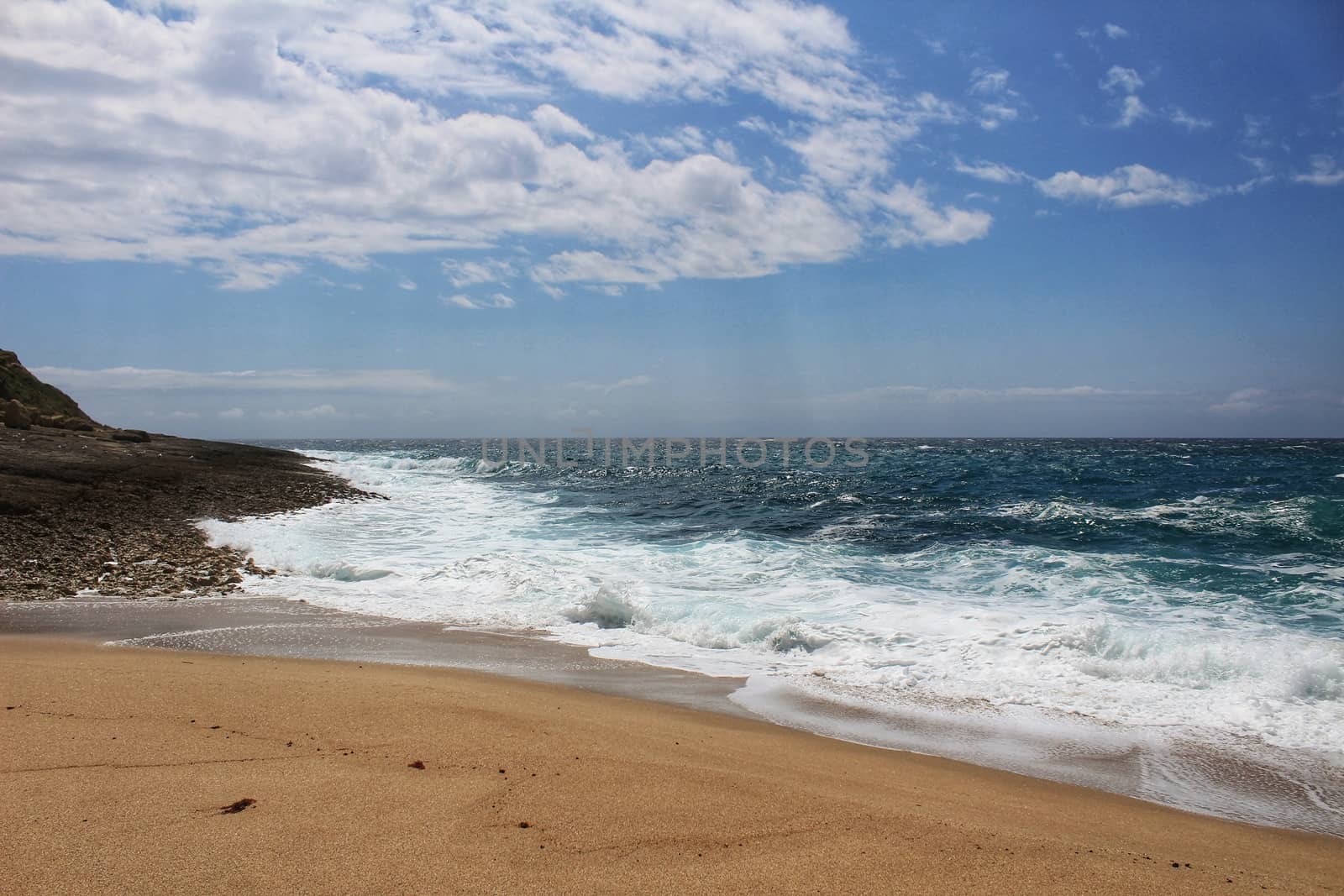 Crystal clear and wild waters in Praia da Foz, Sesimbra, Portugal. Golden sand , seagulls flying, Cliffs and rock formation
