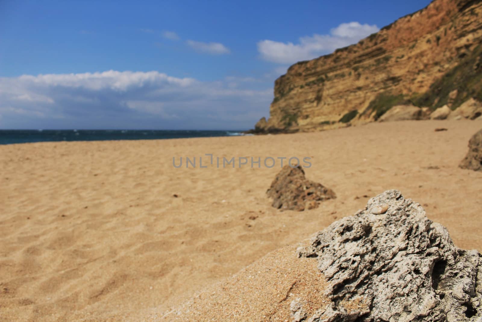 Crystal clear and wild waters in Praia da Foz, Sesimbra, Portugal. Golden sand , seagulls flying, Cliffs and rock formation