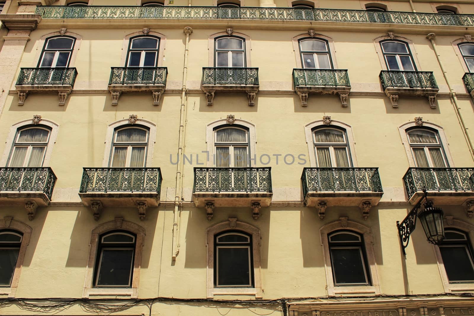 Old colorful and majestic tiled facades with vintage streetlight in Lisbon streets in Spring.