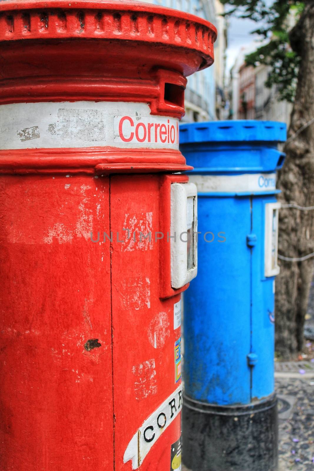 Colorful metallic vintage mail box in red and blue color on the street in Lisbon, Portugal. Word mail written on it.
