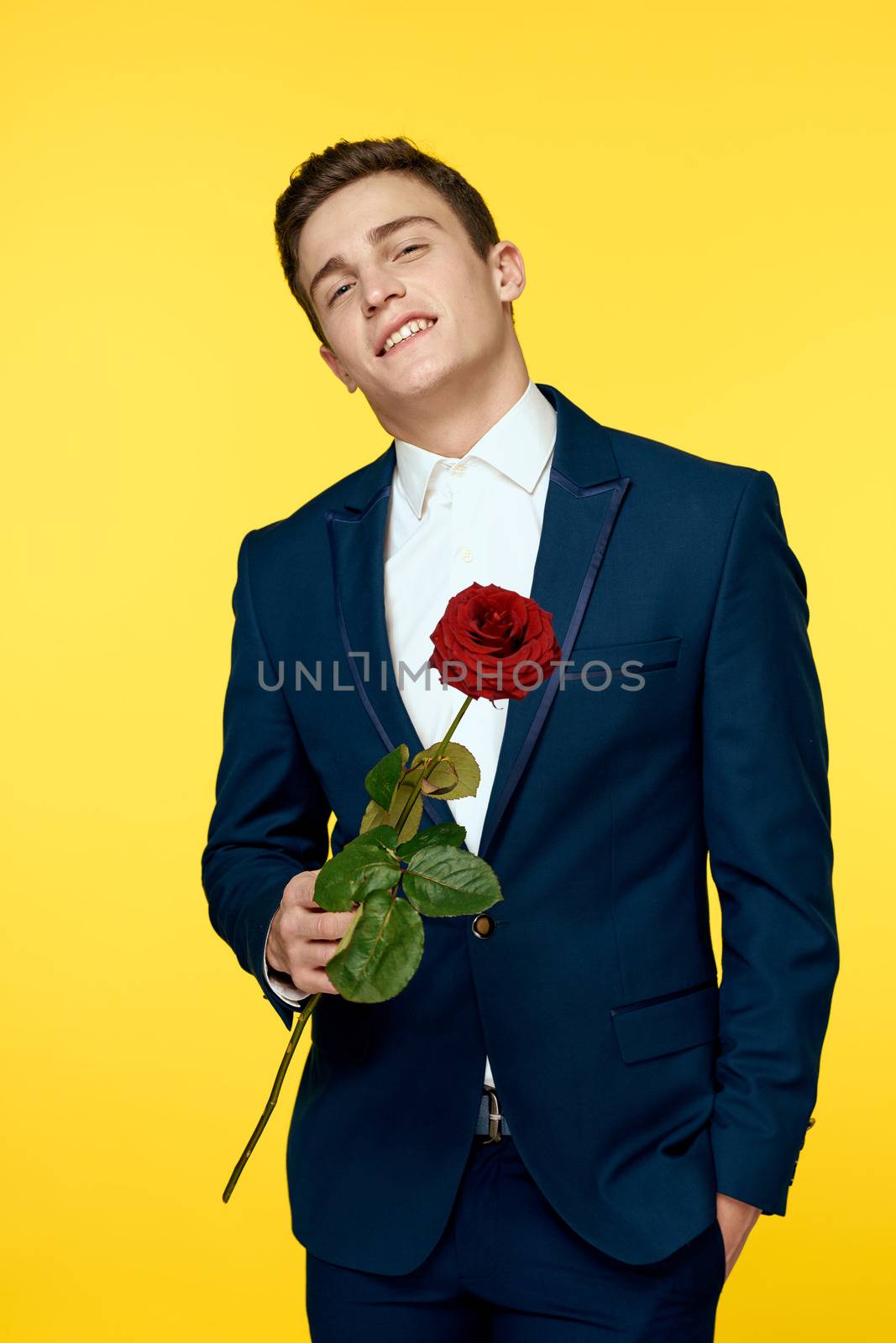 Gentleman in classic suit on yellow background with red rose romance cropped view. High quality photo