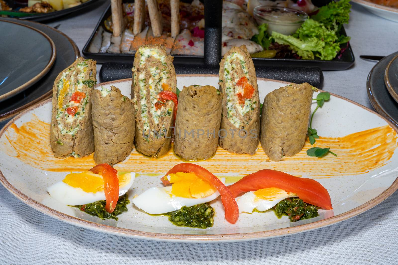 Cold appetizer of liver cake and eggs. Well served dish on a wooden table