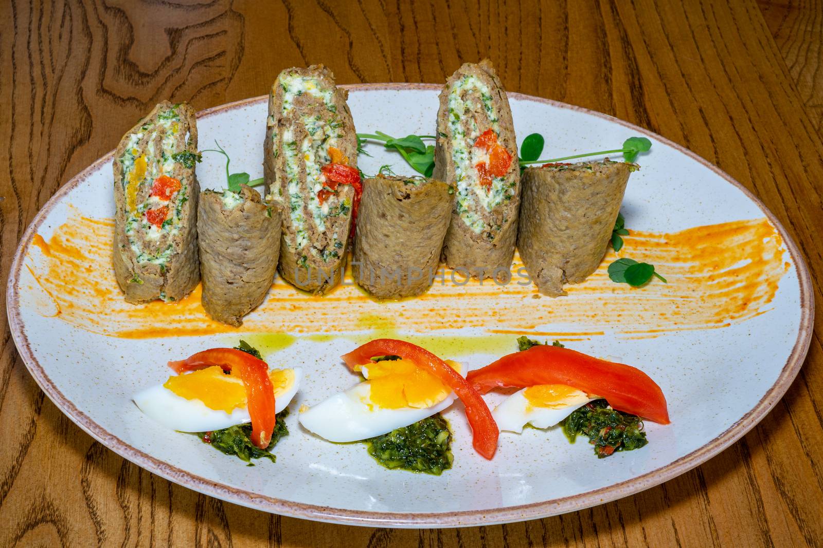 Cold appetizer of liver cake and eggs. Well served dish on a wooden table