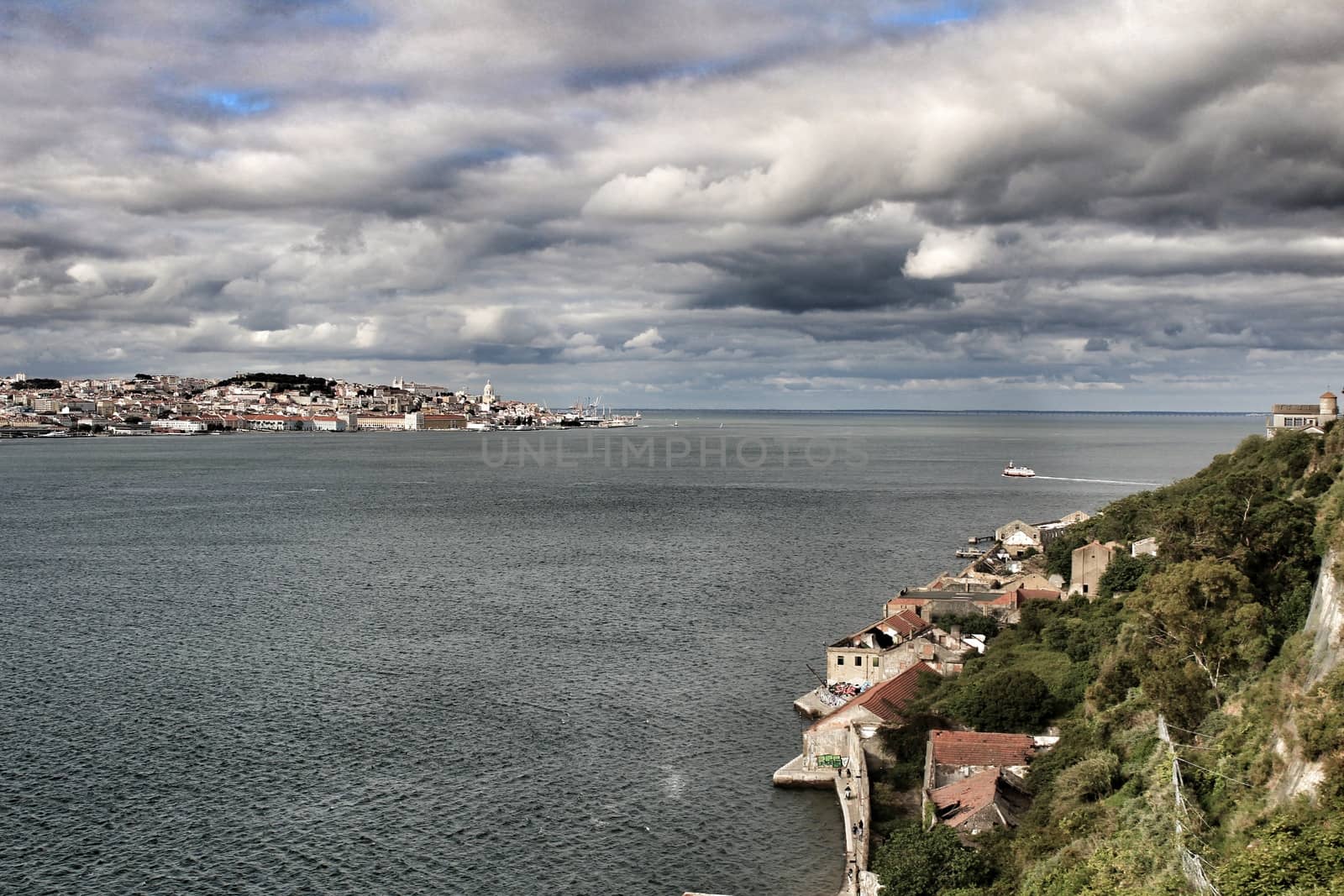 Panoramic of the docks of Cacilhas village and Tagus river on a cloudy day