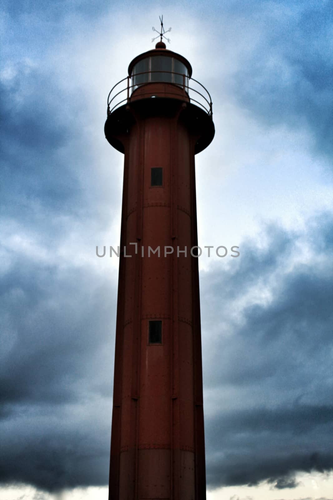 Red lighthouse in the port of Cacilhas village in Lisbon on a gray and cloudy day