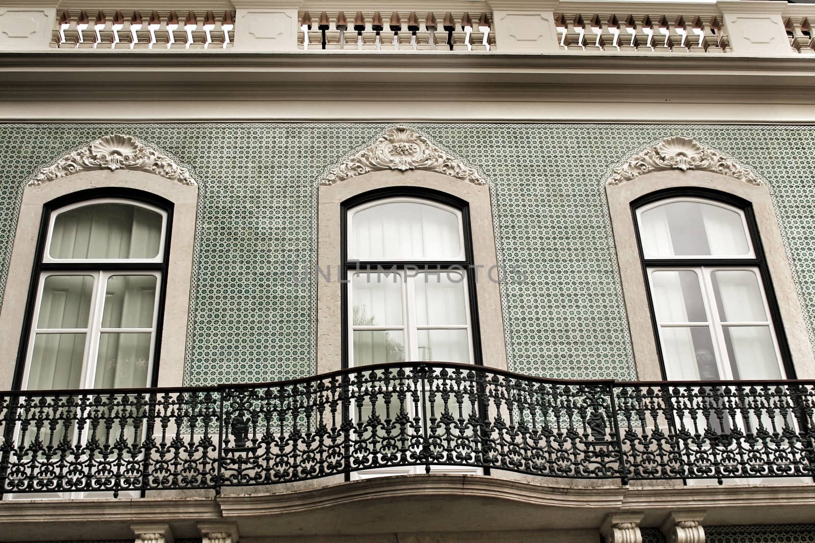 Old colorful and majestic tiled facades with vintage streetlight in Lisbon streets in Spring.