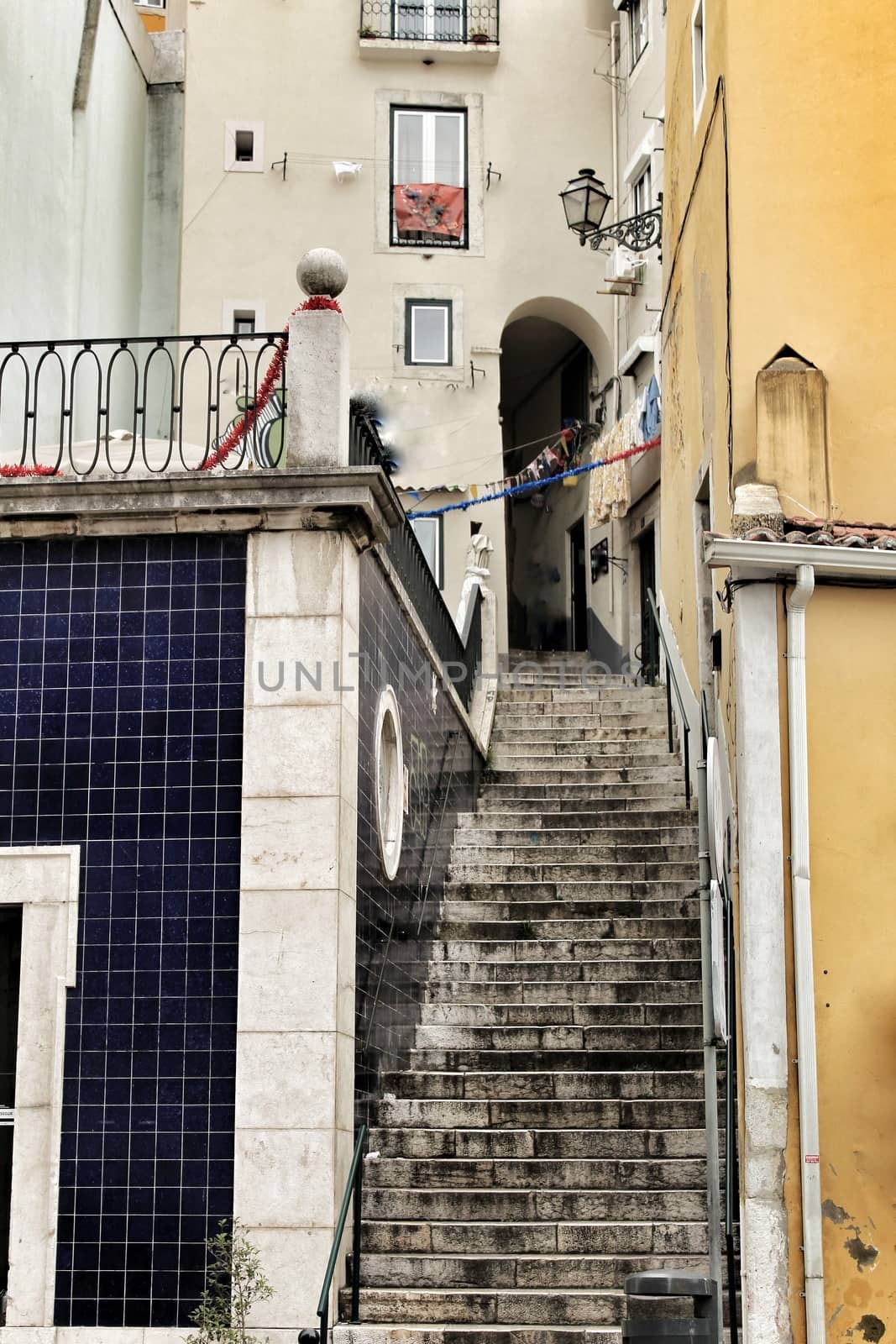 Old colorful houses and narrow streets of Lisbon, Portugal in Spring. Majestic facades and old street lights.