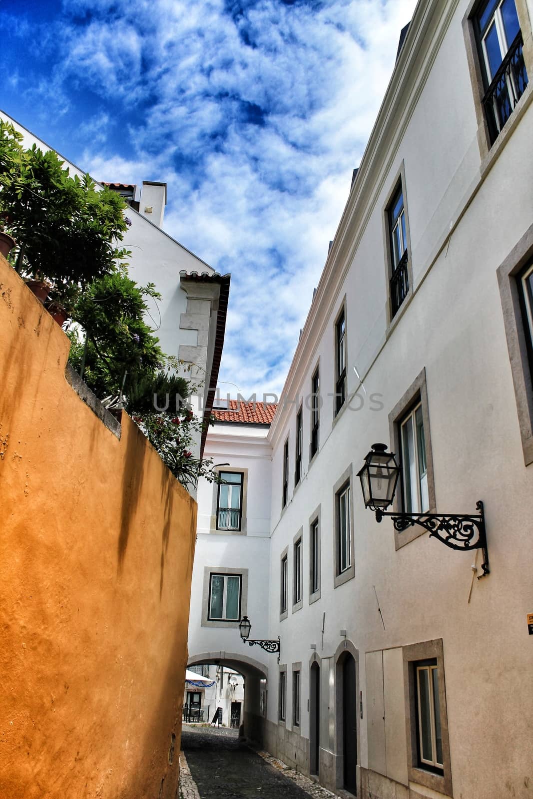 Old colorful houses and narrow streets of Lisbon, Portugal in Spring. Majestic facades and old street lights.