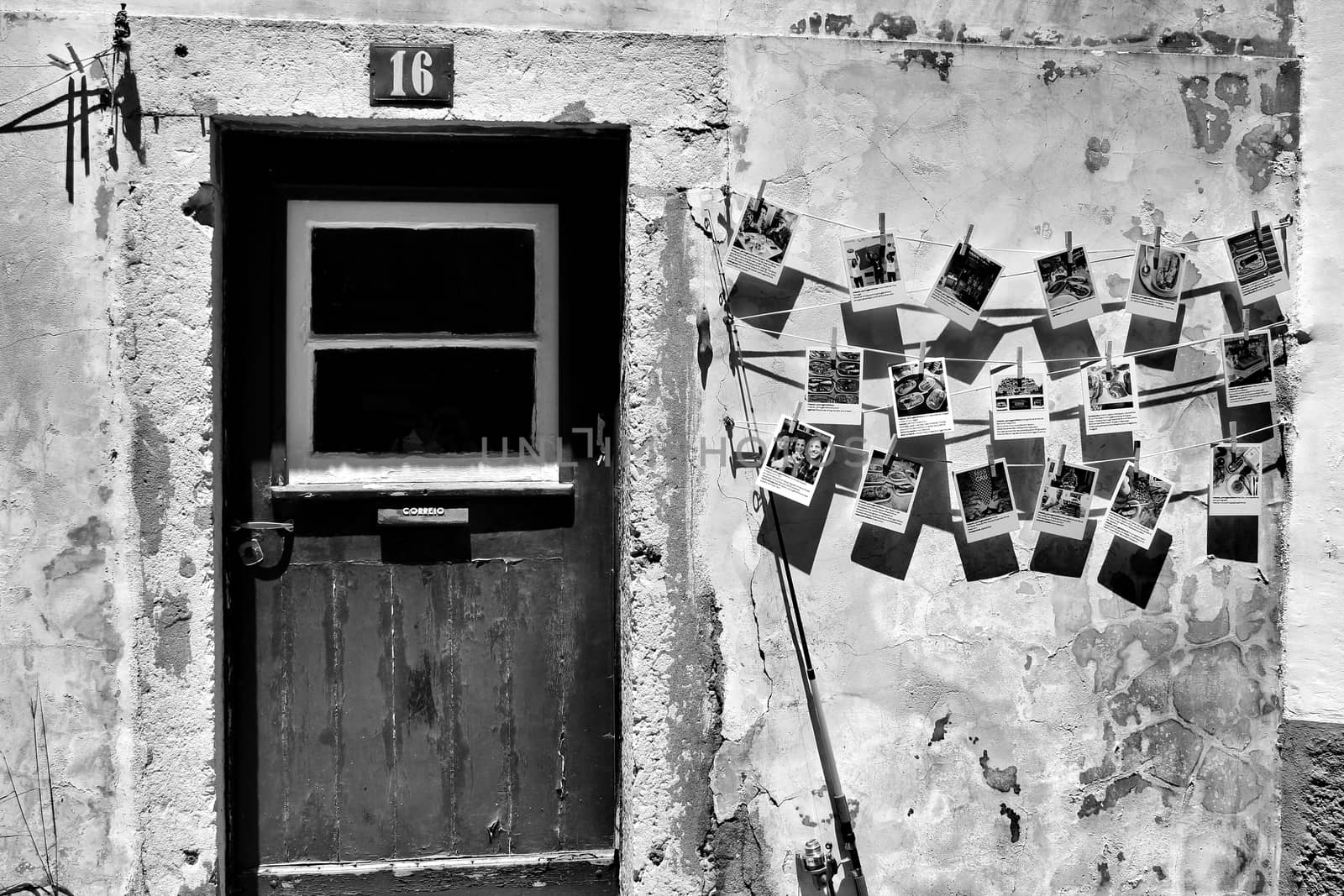 Old wooden door with stone facade and postal cards hanging on the wall.
