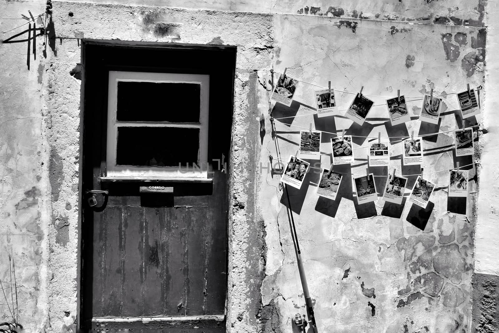 Old wooden door with stone facade and postal cards hanging on the wall.