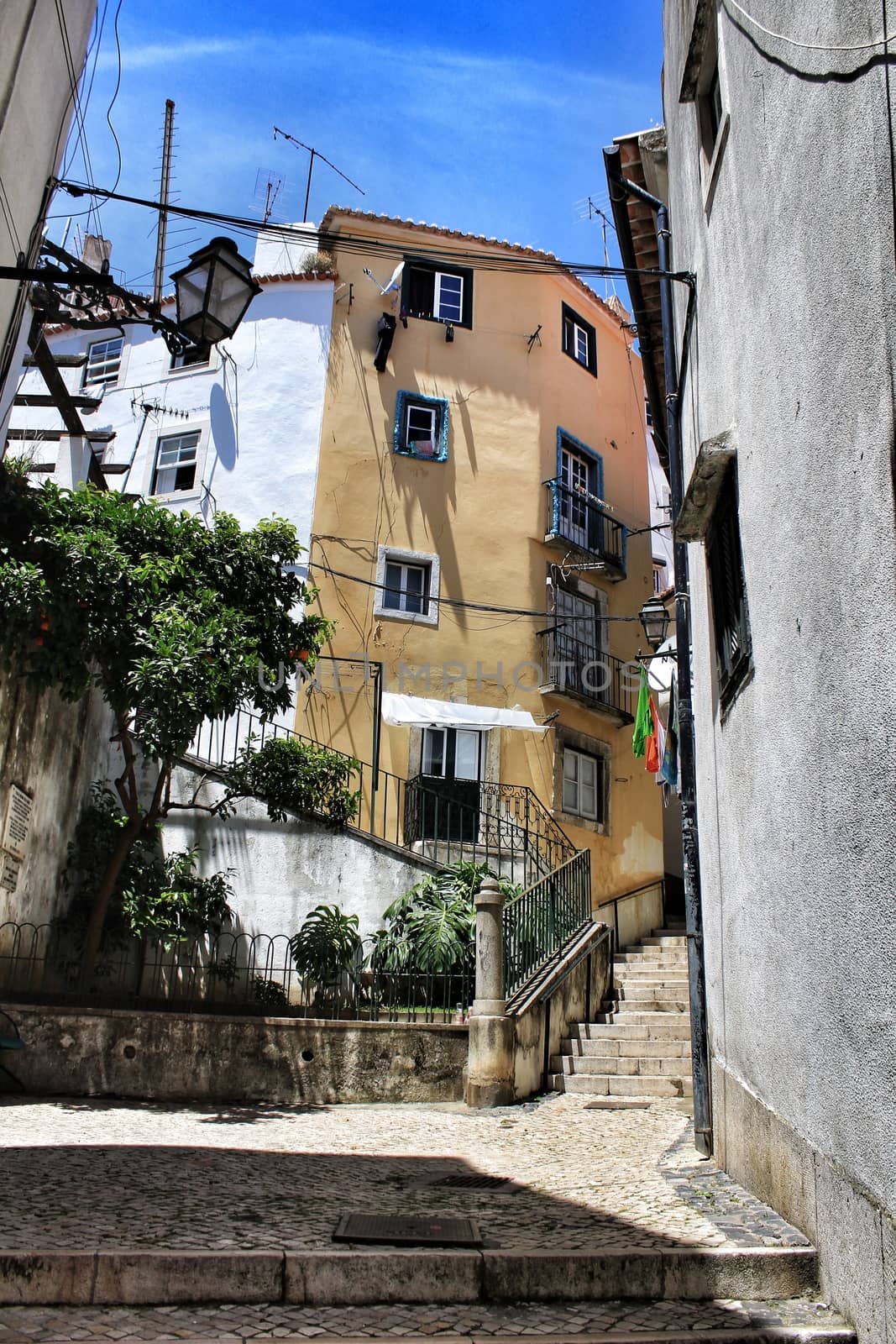 Old colorful houses and narrow streets of Lisbon, Portugal in Spring. Majestic facades and old street lights.