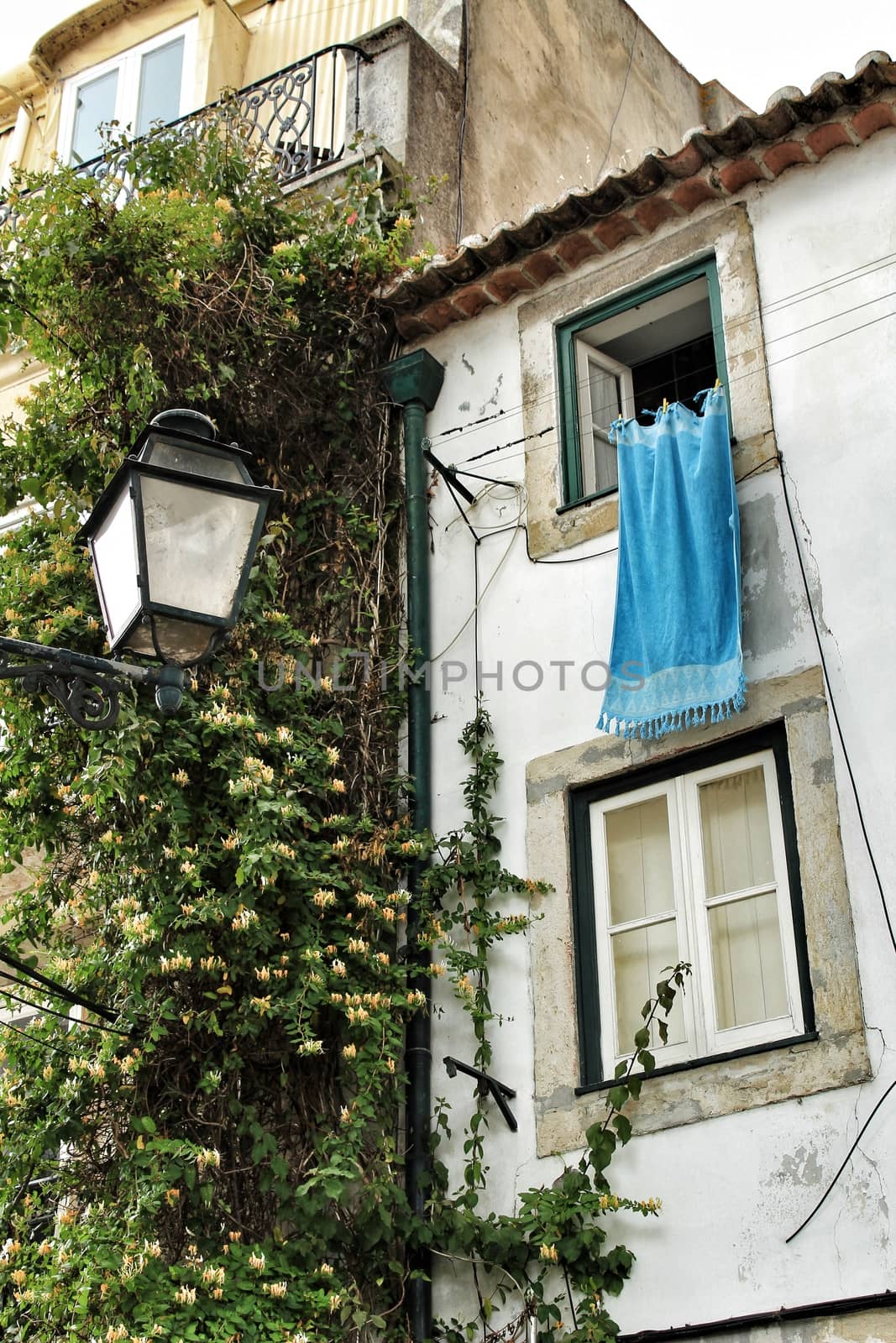 Old facade of typical Lisbon house with hanging clothes in clothesline.