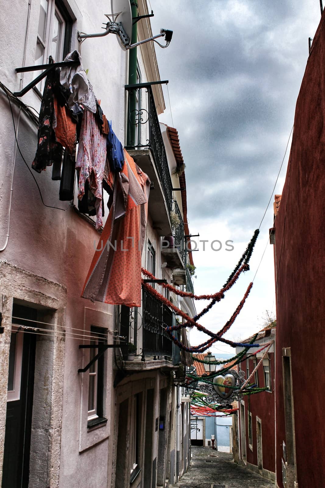 Old facade of typical Lisbon house with hanging clothes in clothesline.