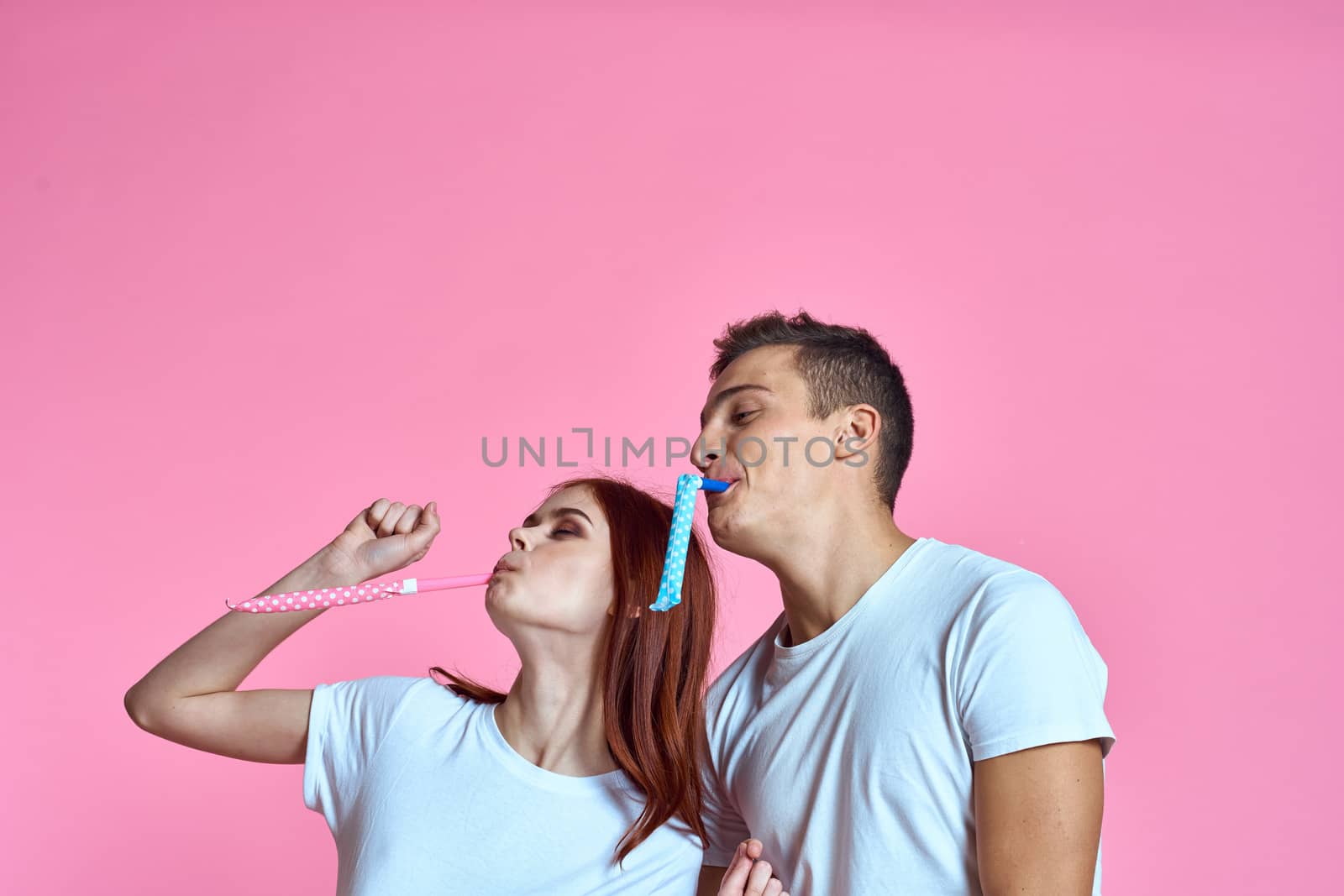 enamored man and woman hugging each other on a pink background cropped with Copy Space family portrait. High quality photo