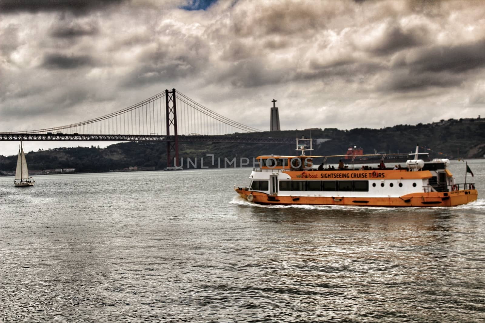 Lisbon, Portugal- June 3, 2018: Passengers boat Sailing along the Tagus river in Lisbon in the afternoon on a cloudy day.