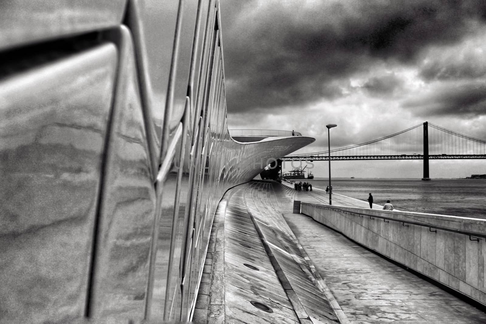 Beautiful ceramic wall of the Maat Museum in Lisbon. 25 of April bridge in the background. Monochrome photography.