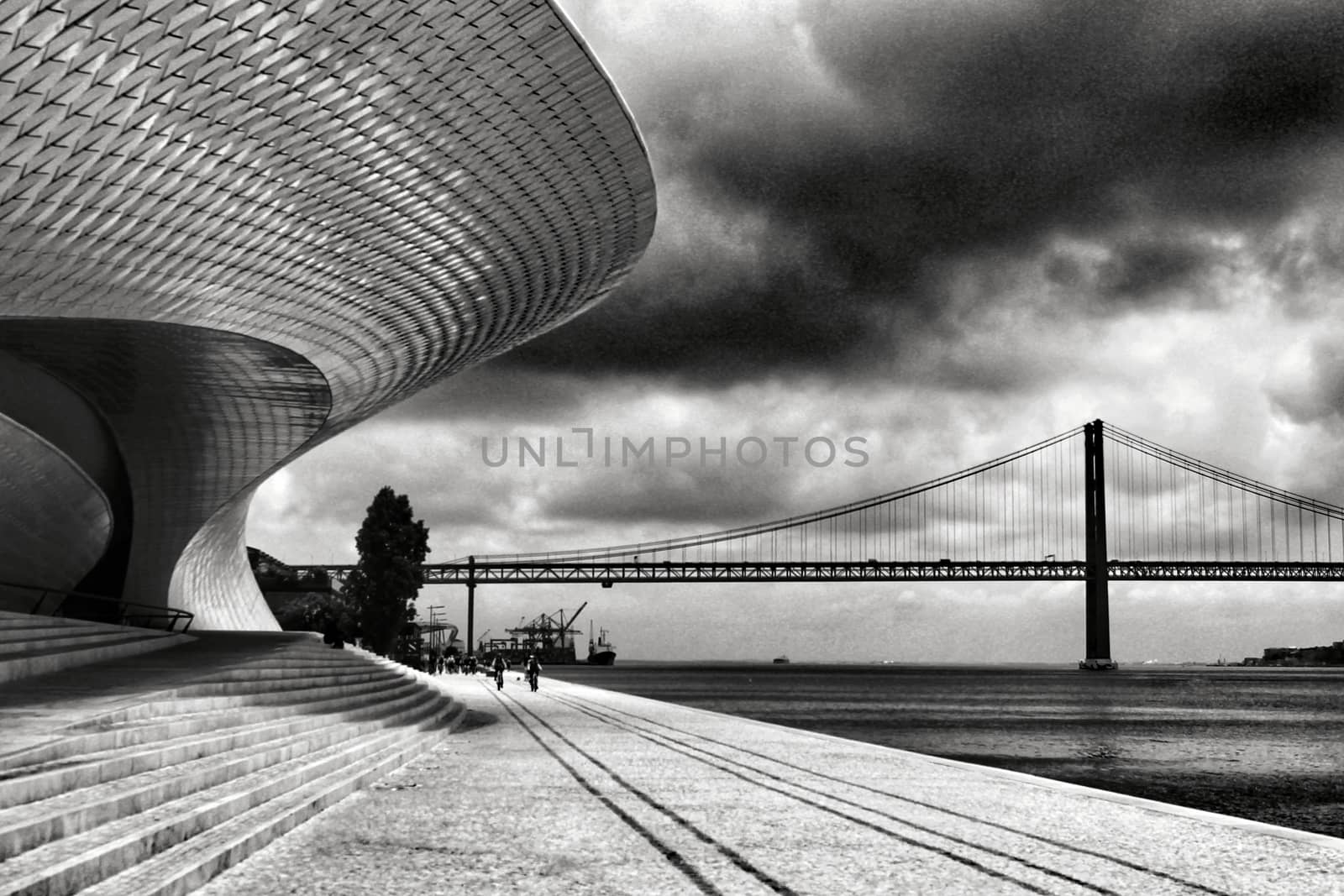 Beautiful ceramic wall of the Maat Museum in Lisbon. 25 of April bridge in the background. Monochrome photography.