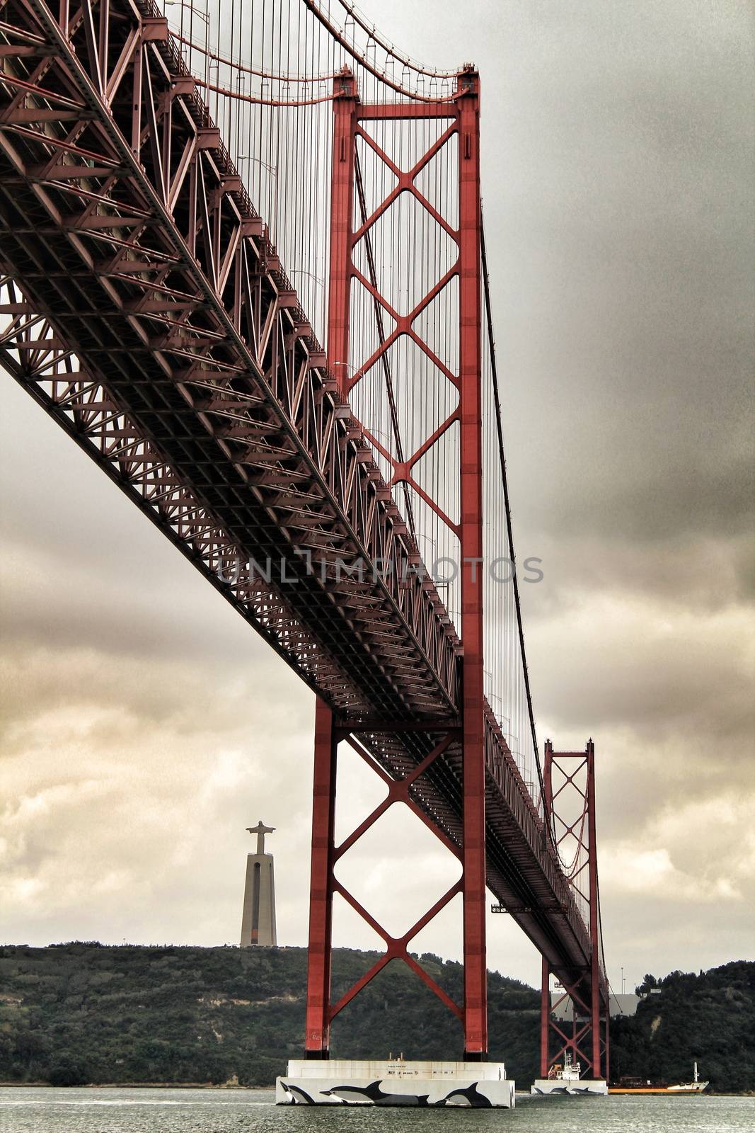 Lisbon, Portugal- June 1, 2018:Banks of the river Tagus in Lisbon in Spring on a cloudy day. Beautiful 25th April bridge structure.