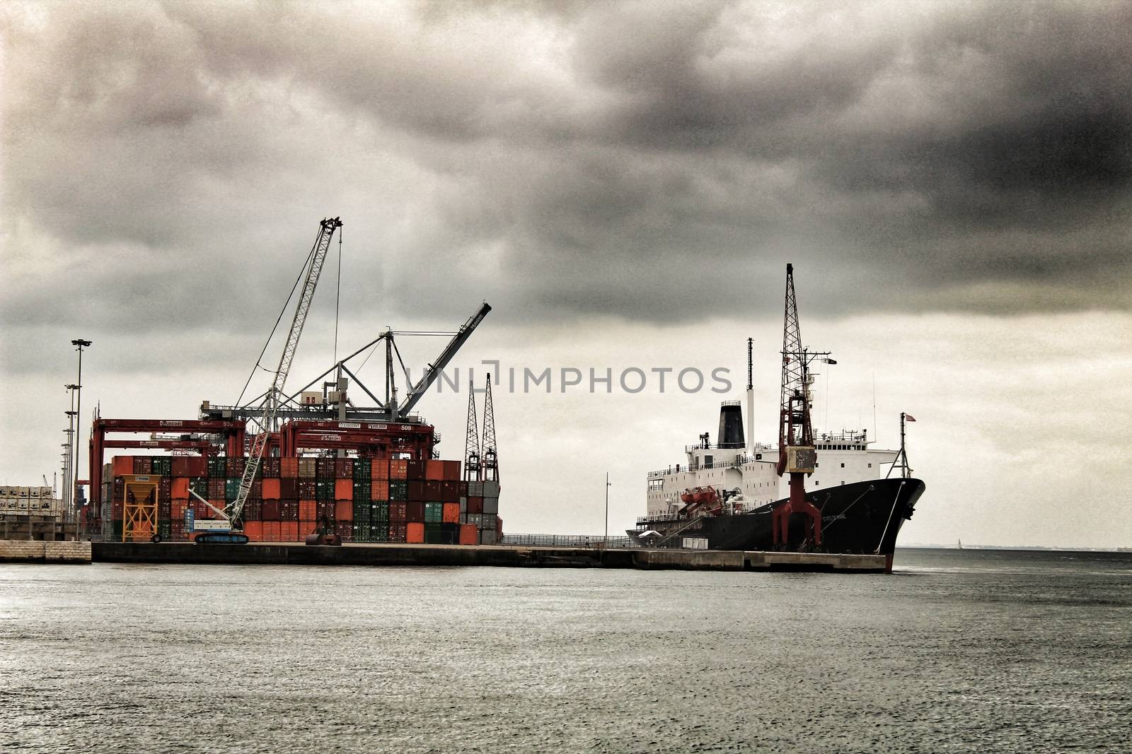 Crane and containers on the dock in the port of Lisbon by soniabonet