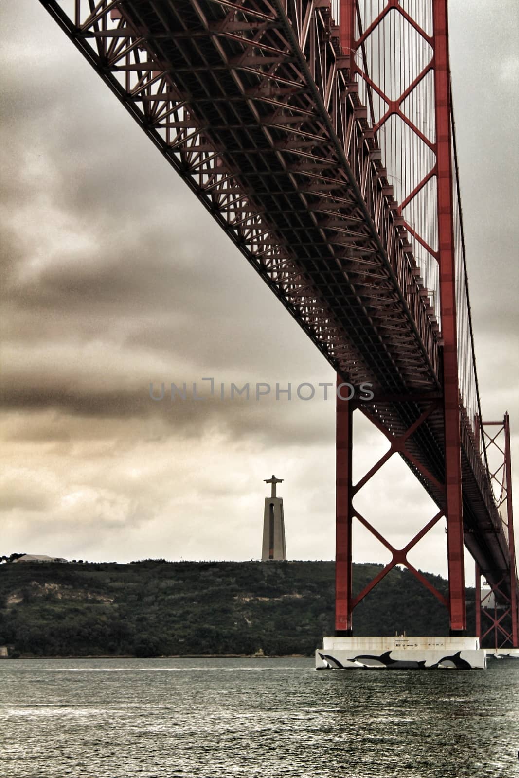 Banks of the river Tagus in Lisbon in Spring on a cloudy day. Beautiful 25th April bridge structure.