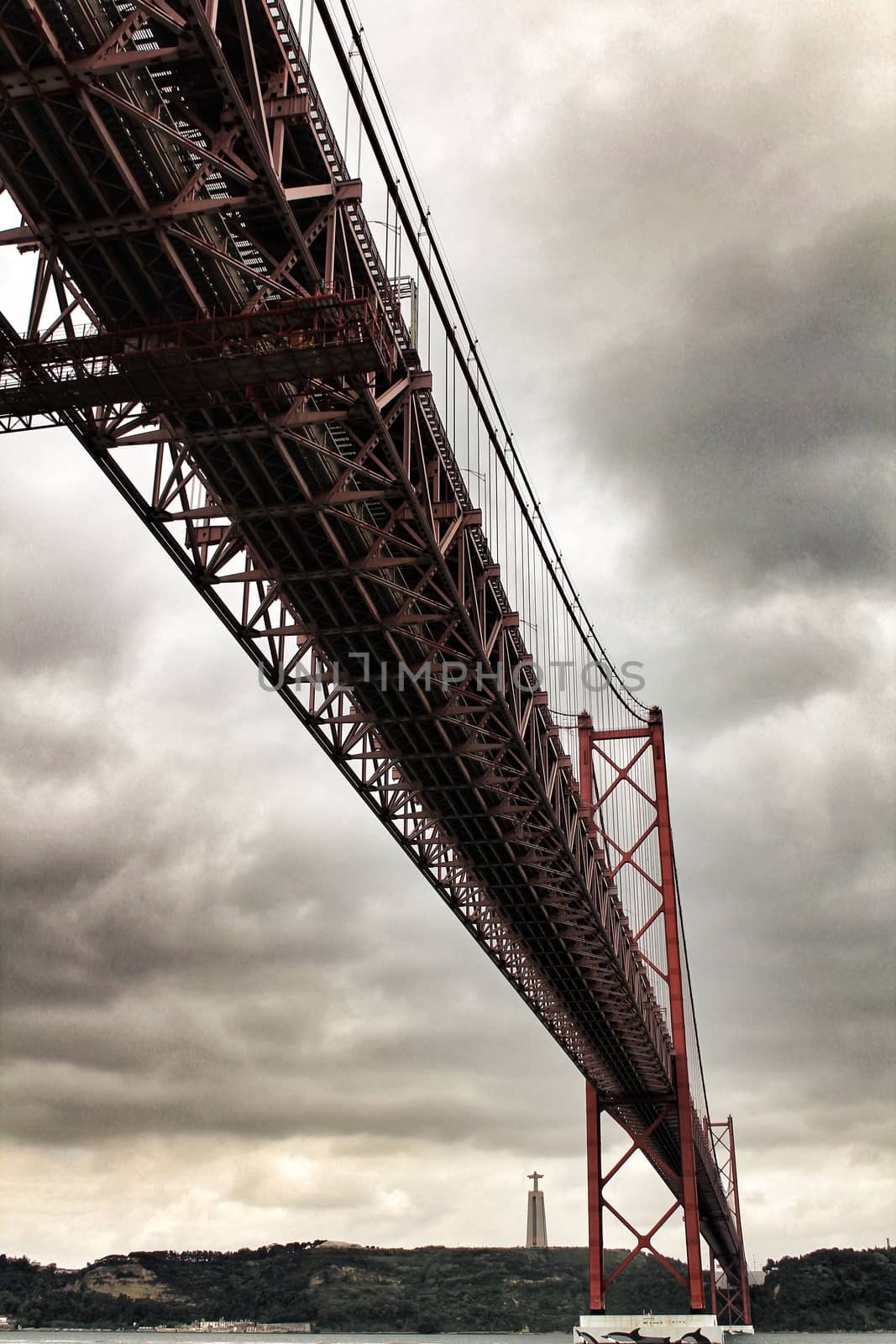 Banks of the river Tagus in Lisbon in Spring on a cloudy day. Beautiful 25th April bridge structure.