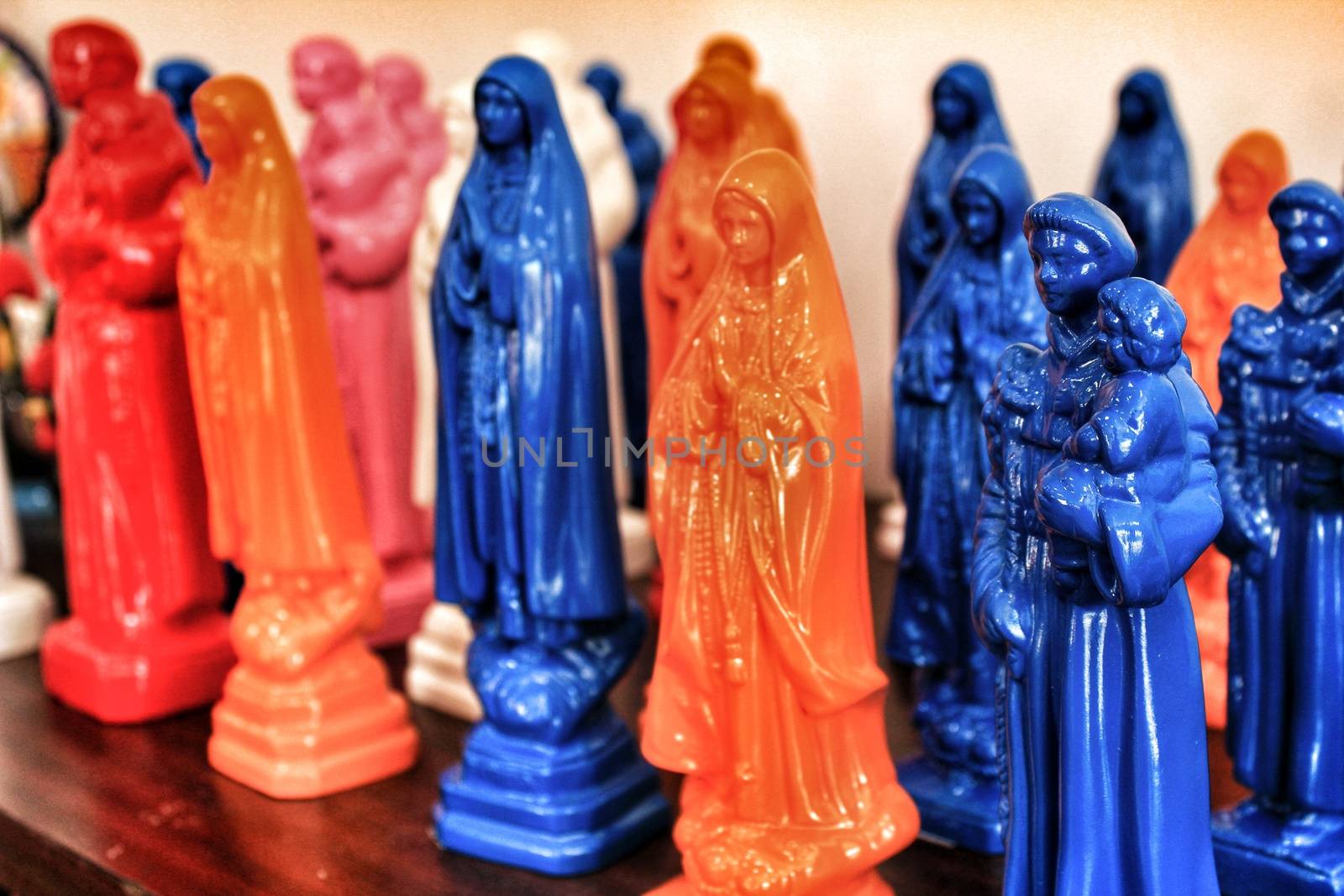 Colorful and typical souvenirs of Saint Anthony figurines and Fatima virgin in a showcase in Lisbon, Portugal