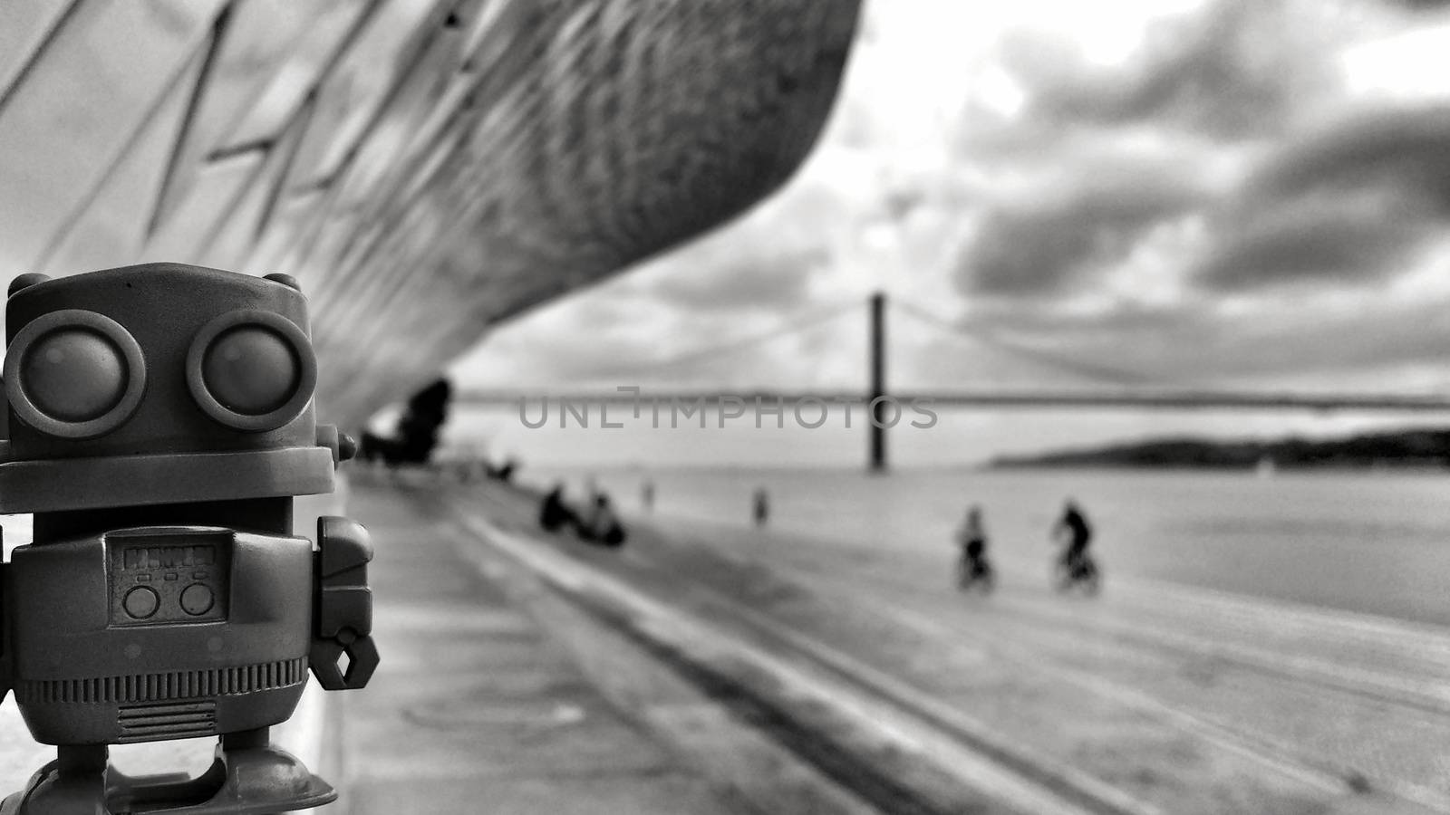 Toy robot on the banks of the Tagus River in Lisbon in a Cloudy day