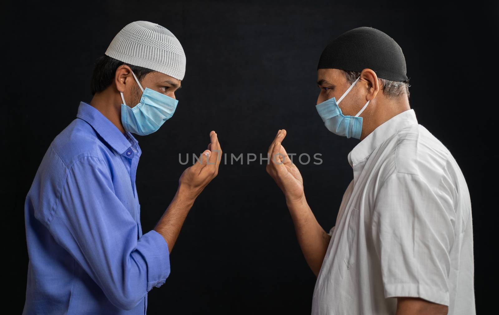 Two muslim men in medical mask greeting or salam each other in Islamic way while Maintaining social distancing - Concept of Coronavirus or covid-19 safety measures and new normal lifestyle. by lakshmiprasad.maski@gmai.com