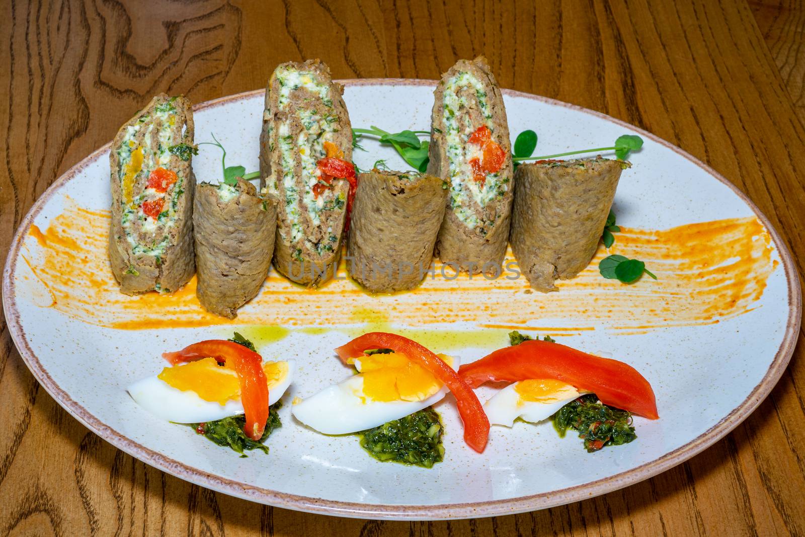 Cold appetizer of liver cake and eggs. Well served dish on a wooden table