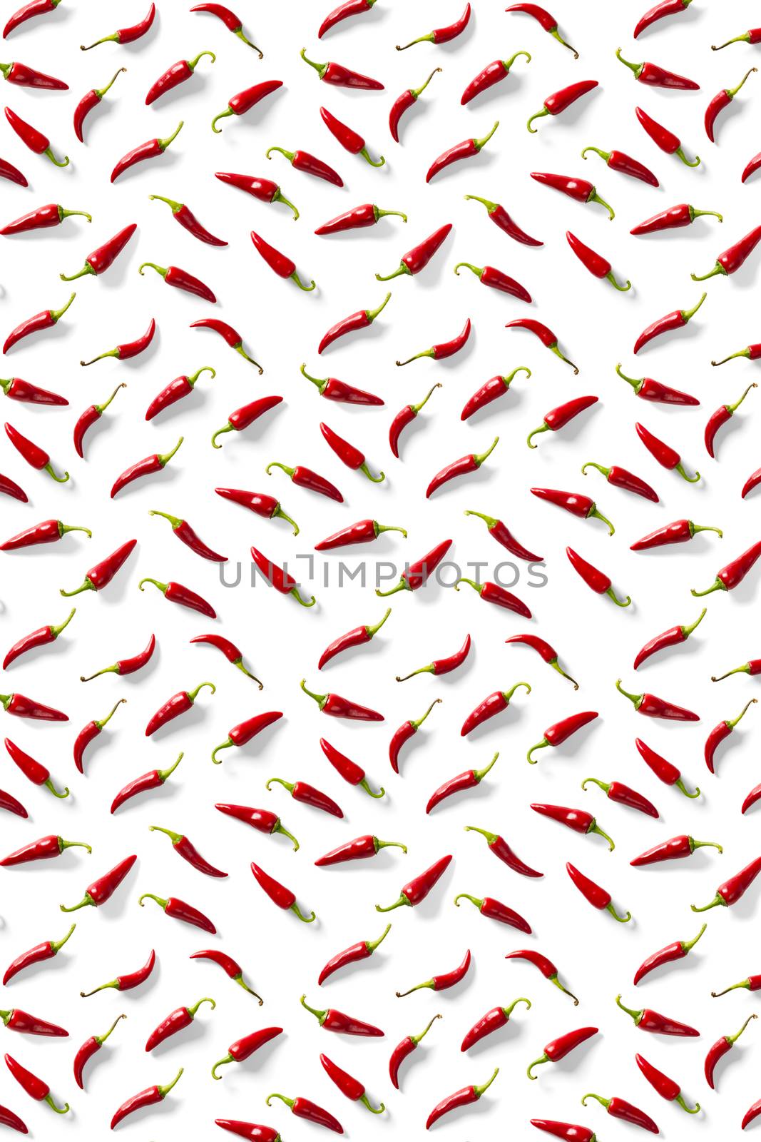 Creative background made of red chili or chilli on white backdrop. Minimal food backgroud. Red hot chilli peppers background. by PhotoTime