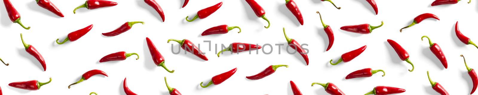 Creative background made of red chili or chilli on white backdrop. Minimal food backgroud. Red hot chilli peppers background, not pattern