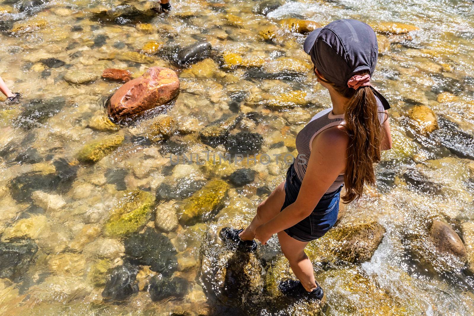 Teenage girl wading in the river, feet wet in Zion National Park, Utah, USA