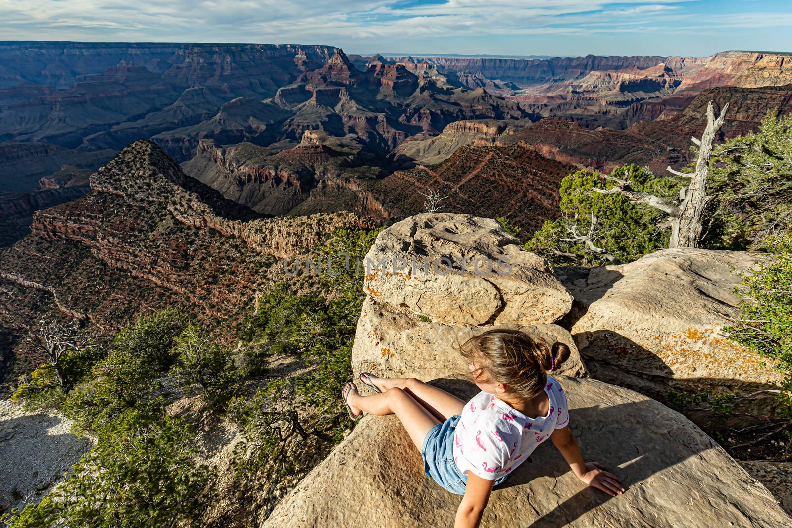 Teenage girl sitting on the edge of the rim of Grand Canyon Nati by mkenwoo